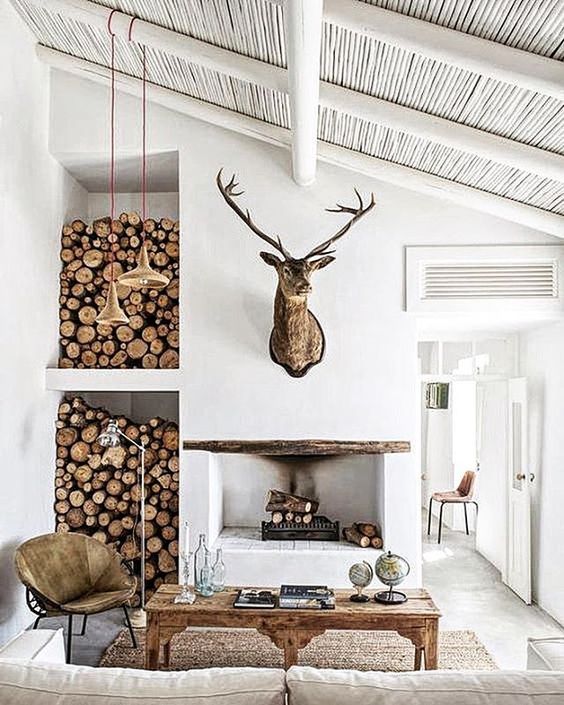 a fireplace and firewood storage by its side for a modern yet rustic space, a sisal rug and whitewashed wood