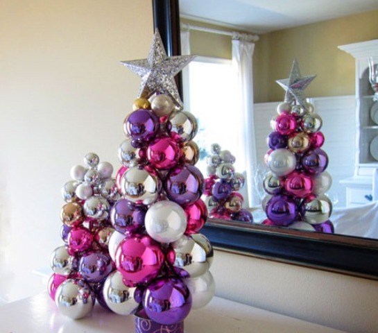 a duo of tabletop Christmas trees of colorful Christmas ornaments glued to each other with a silver star on top
