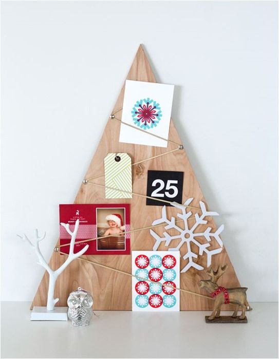 a simple tabletop Christmas tree decorated with Christmas cards and snowflakes plus gift tags for a modern space