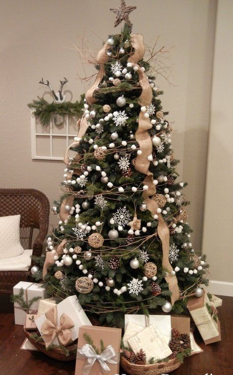 a chic Christmas tree with white snowflakes, ball ornaments, twigs, pompomg garlands, burlap ribbons and vine ornaments