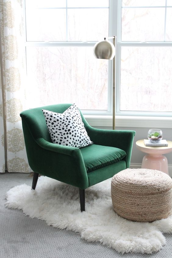 a faux fur throw, a jute ottoman, a printed pillow and a metallic lamp make the space catchy and interesting