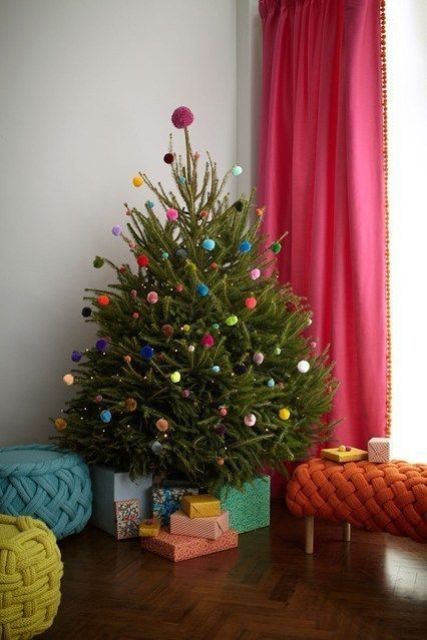 a small Christmas tree decorated only with colorful pompoms and LEDs is a fun and whimsy idea
