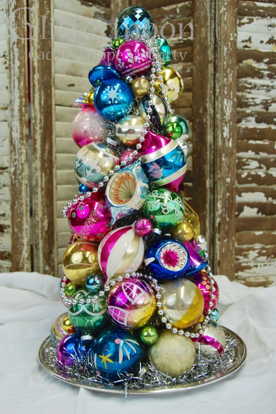 a super colorful and vintage Christmas tree made of ornaments and beads on a tray is a creative idea