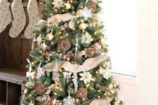 22 a chic rustic Christmas tree with vine and snowflake ornaments, pinecones, lights and lots of burlap plus a burlap bow on top