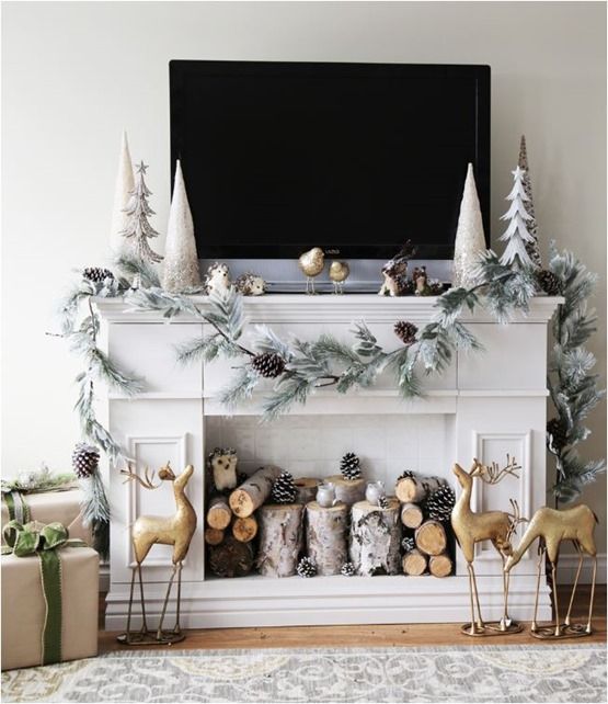 a mantel decorated with a snowy evergreens and snowy pinecones garland for a real winter feel