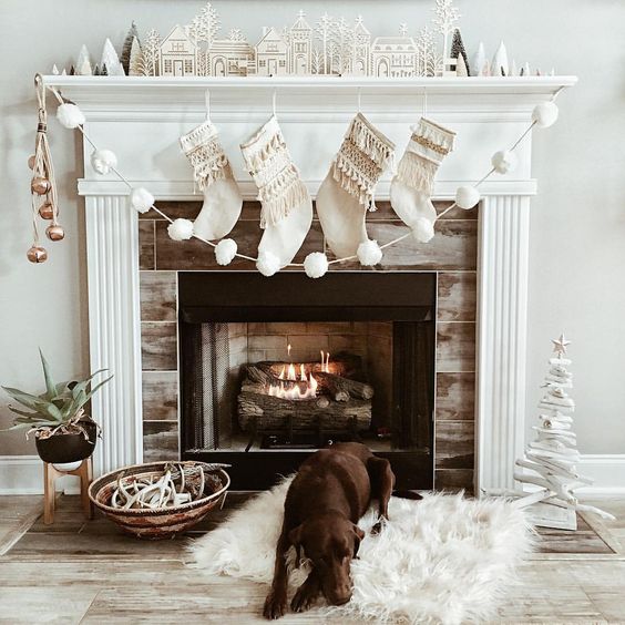 a mantel styled with metallic jingle bells and a white pompom garland for Christmas