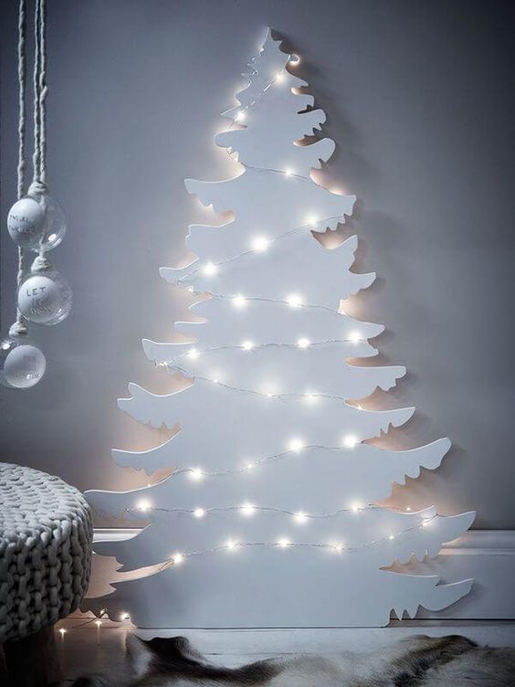 a white plywood Christmas tree decorated with lights instantly creates a winter wonderland feel in your home