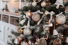 23 a glam rustic Christmas tree decorated with wicker bells, wooden and metal ornaments and some ball ornaments and pinecones