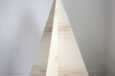 23 an ultra-minimalist Christmas tree of plywood with no decor, just some gifts and faux fur
