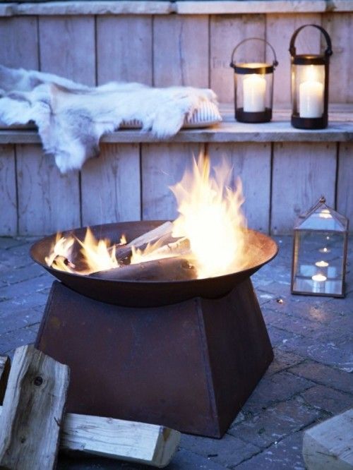 candle lanterns, pillows and faux fur, a large fire bowl are all you need for a hygge feeling