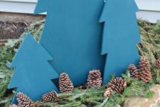 24 easy plywood trees in blue with evergreens and pinecones are great for creating a simple outdoor display for Christmas