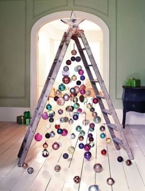 a chic ladder christmas tree with colorful ornaments all over and on the floor for a messy and relaxed touch