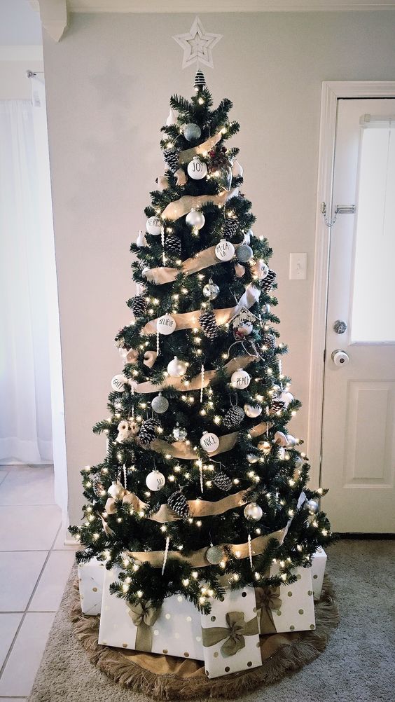 a rustic glam Christmas tree with white and silver ornaments, pinecones, icicle ornaments and lights