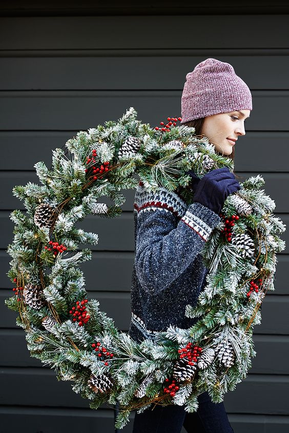 a snowy evergreen wreath with snowy pinecones and fake berries feels very holiday-like and can be easily DIYed