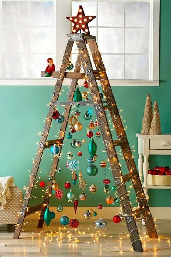 a fun Christmas tree of a laddder and colorful ornaments plus lights and a shiny star on top