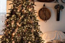 26 a rustic luxe Christmas tree with snowy and gilded pinecones, burlap ribbons, large metal ornaments and lots of lights