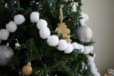 Christmas tree decor with gold ornaments and leaves, snowflakes and white pompom garlands