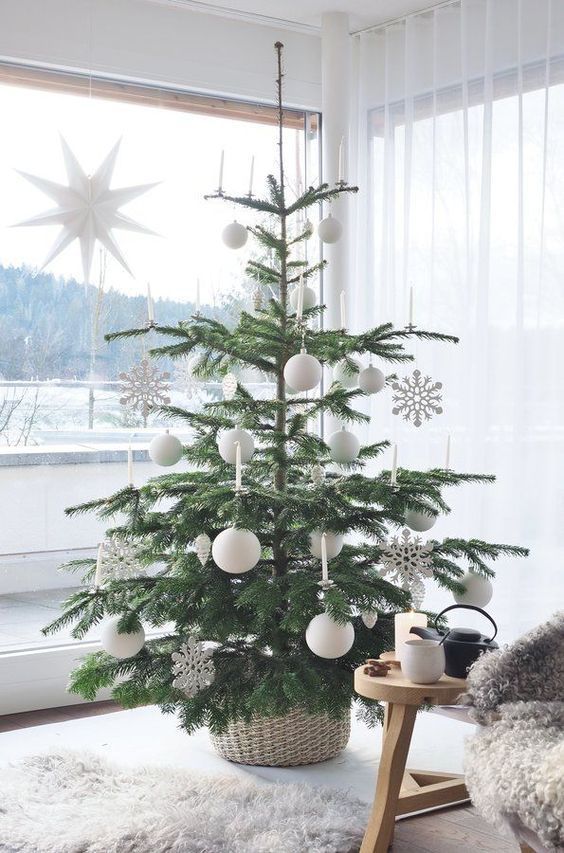 a Nordic Christmas tree decorated with snowflakes and white baubles is a cool and catchy idea for a Scandi space