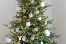 a Nordic Christmas tree decorated with white ornaments, stars, trees, lights and house pieces is cool