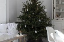 a Nordic Christmas tree decrated with white stars, dried citrus and some lights is a minimal and chic decoration
