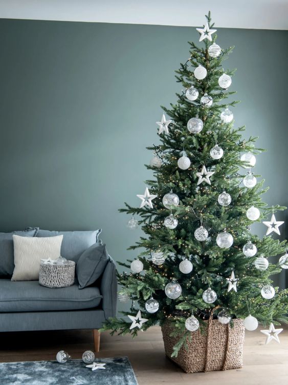 a Nordic Christmas tree styled with lights, white baubles and star ornaments is a cool and catchy idea