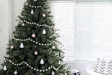 a Scandinavian Christmas tree decorated with silver and copper baubles, white Christmas tree ornaments and white pompoms is a chic idea