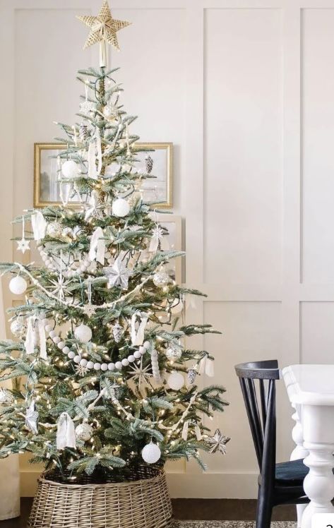 a Scandinavian Christmas tree styled with white ornaments, beads, garlands, stars and lights plus a star topper