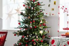 a bright Scandinavian Christmas tree with red and wooden ornaments and banners is a super cool idea