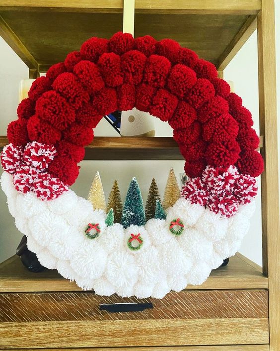 a bright ombre Christmas wreath in red and white, with bottle brush Christmas trees and mini wreaths