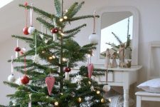 a classic Nordic Christmas tree decorated with red and white ornaments and felt hearts plus some lights is a very cute idea