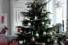 a classic Scandinavian Christmas tree with red and white ornaments, glass and felt ones is a lovely idea for every space