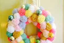 a colorful pompom Christmas wreath with bright ornaments is a cool Christmas decor idea if you love color