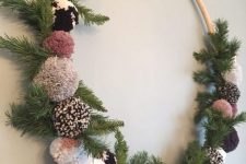 a cozy Christmas wreath of fir branches and pretty ombre and neutral-colored pompoms is a lovely craft for the holidays