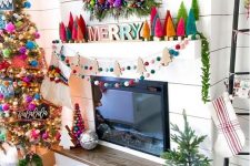 a fab colorful Christmas space with bright pompom garlands, bright bottle cleaner Christmas trees, a wreath with evergreens and bright ornaments and colorful pillows