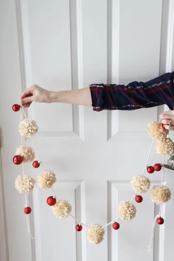 a gorgeous holiday garland of white pompoms and red ornaments to decorate your Christmas tree