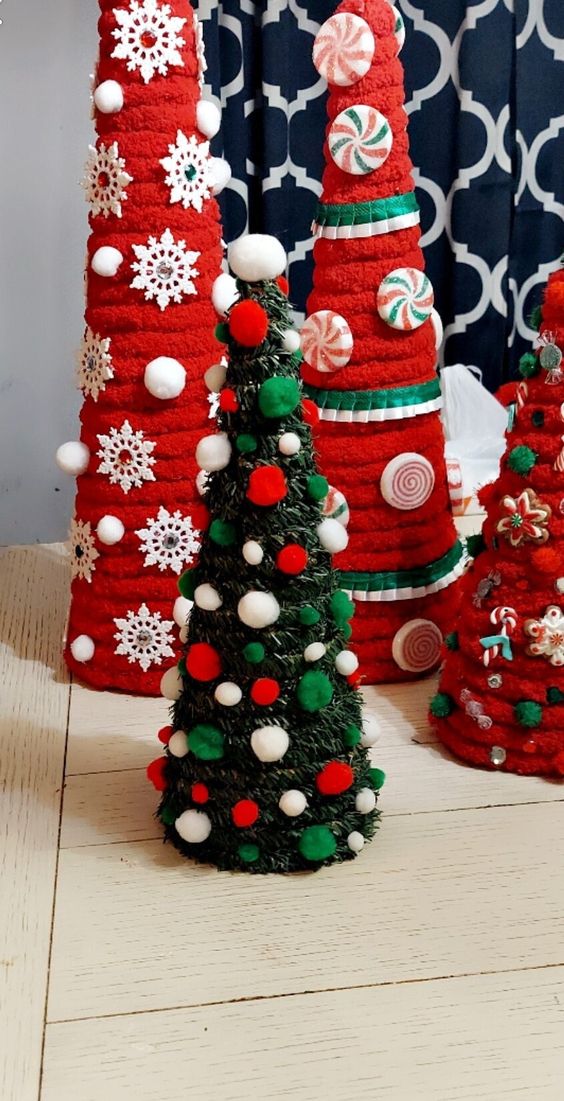 A green cone shaped Christmas tree with colorful pompoms covering it is a cool tabletop Christmas decoration