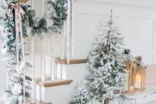 a lovely winter wonderland Christmas space with a snowy evergreen garland, a duo of flocked Christmas trees