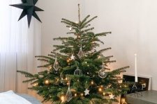 a minimalist and Scandinavian Christmas tree with lights, stars and himmeli ornaments is a lovely idea