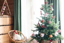 a small Christmas tree for a kids’ room decorated with striped ornaments and funny pieces is a cool idea