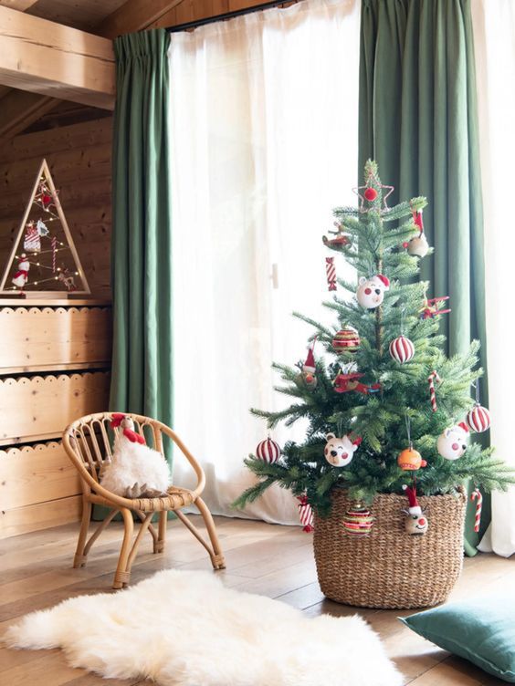 a small Christmas tree for a kids' room decorated with striped ornaments and funny pieces is a cool idea