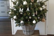 a small Christmas tree on a crate, with white and wood slice ornaments and lights is awesome