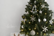 a small Scandinavian Christmas tree decorated with white ornaments and lights is a cool and catchy idea