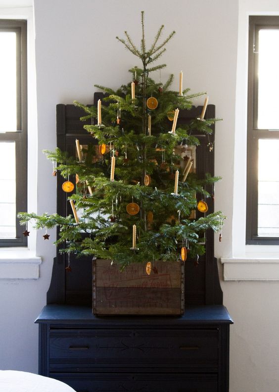 a small vintage Christmas tree with citrus slices and candles is a great rustic decor idea