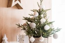 a stylish and simple small Christmas tree decorated with twine and color block neutral ornaments and put into a crochet basket