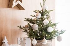 a stylish and simple tabletop Christmas tree decorated with twine and color block neutral ornaments and put into a crochet basket