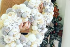 beautiful neutral Christmas pompom wreaths with tiny wooden snowflakes and stars are cool for holiday decor