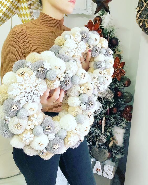 beautiful neutral Christmas pompom wreaths with tiny wooden snowflakes and stars are cool for holiday decor