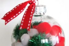 clear glass Christmas ornaments with red and white pompoms and green tinsel pieces, with red ribbon are fun and cool