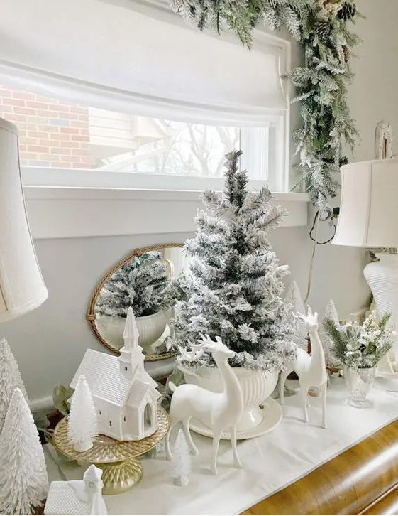 lovely winter wonderland decor with deer figurines, a church, bottle brush and a usual flocked Christmas tree in a super bowl is very chic