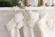 white stockings decorated with pompoms can accent your mantel, they will add interest to any space